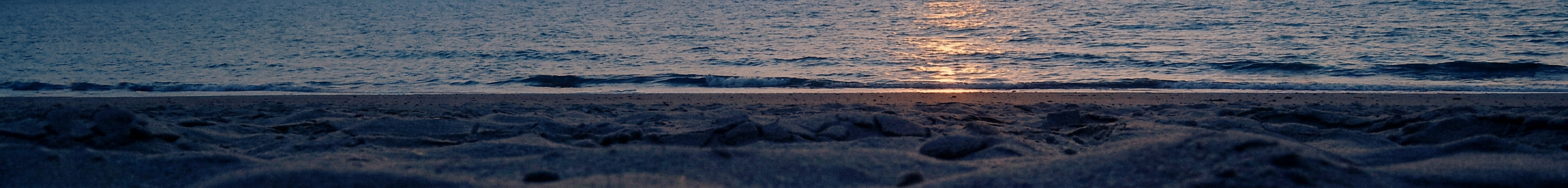 Still shoreline at dusk with light reflecting off the water