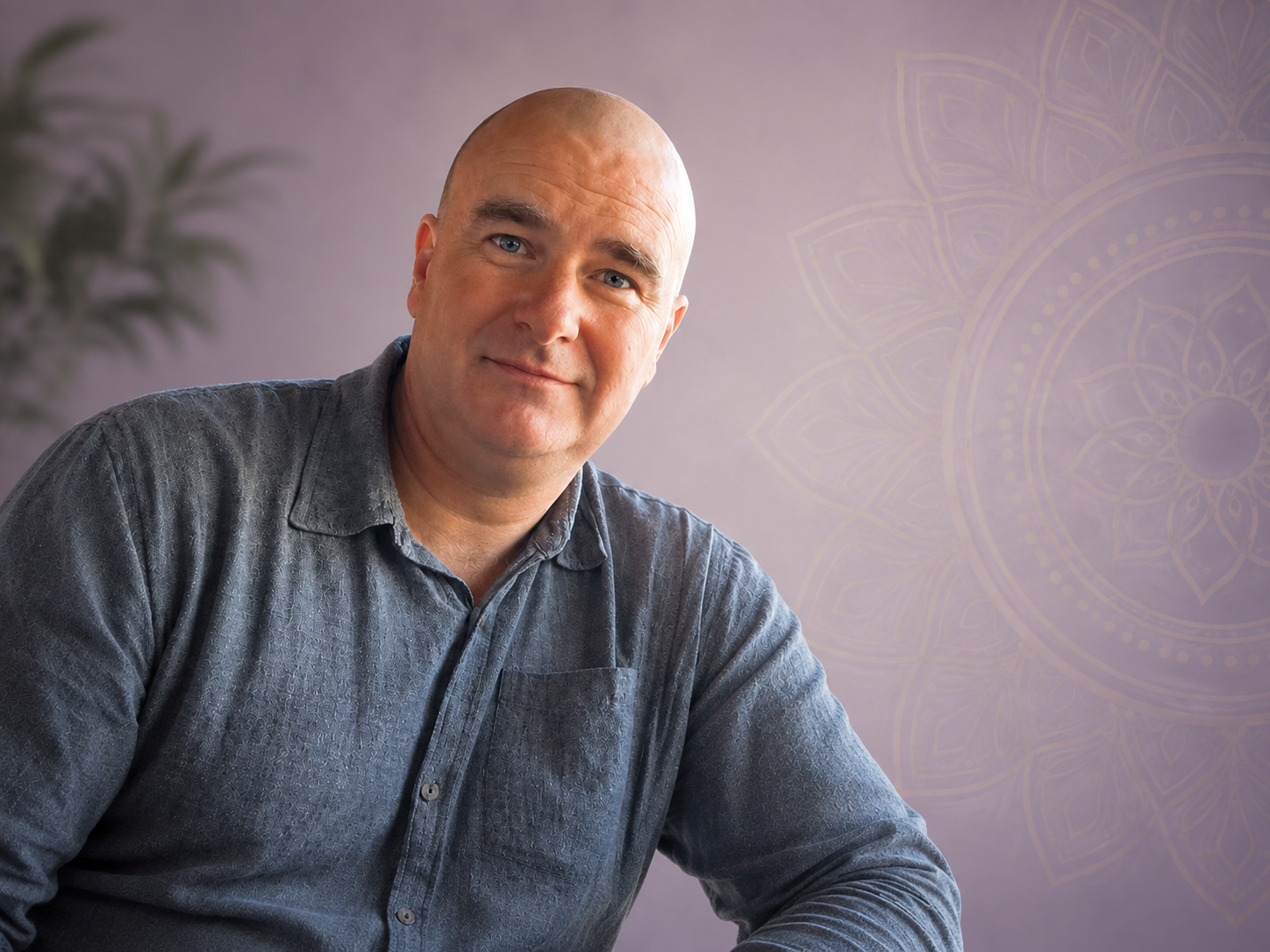 Stuart Marks — calm and present, seated in a softly lit room with a mandala motif on the wall