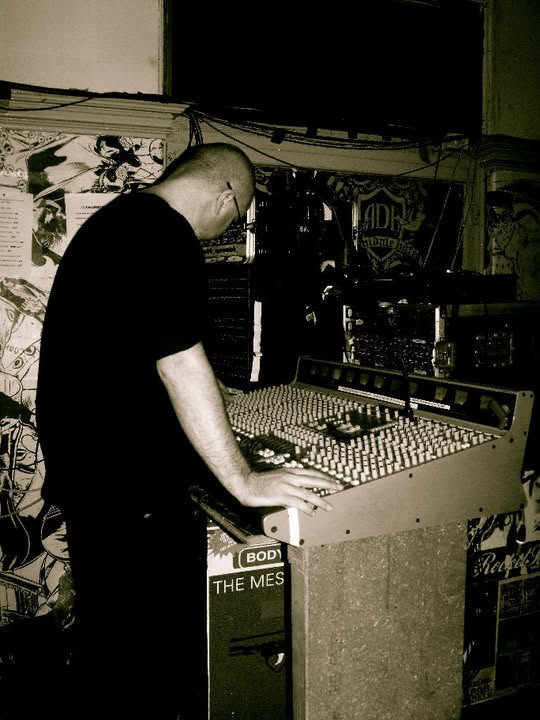 Stuart at a mixing console during a live show, side view